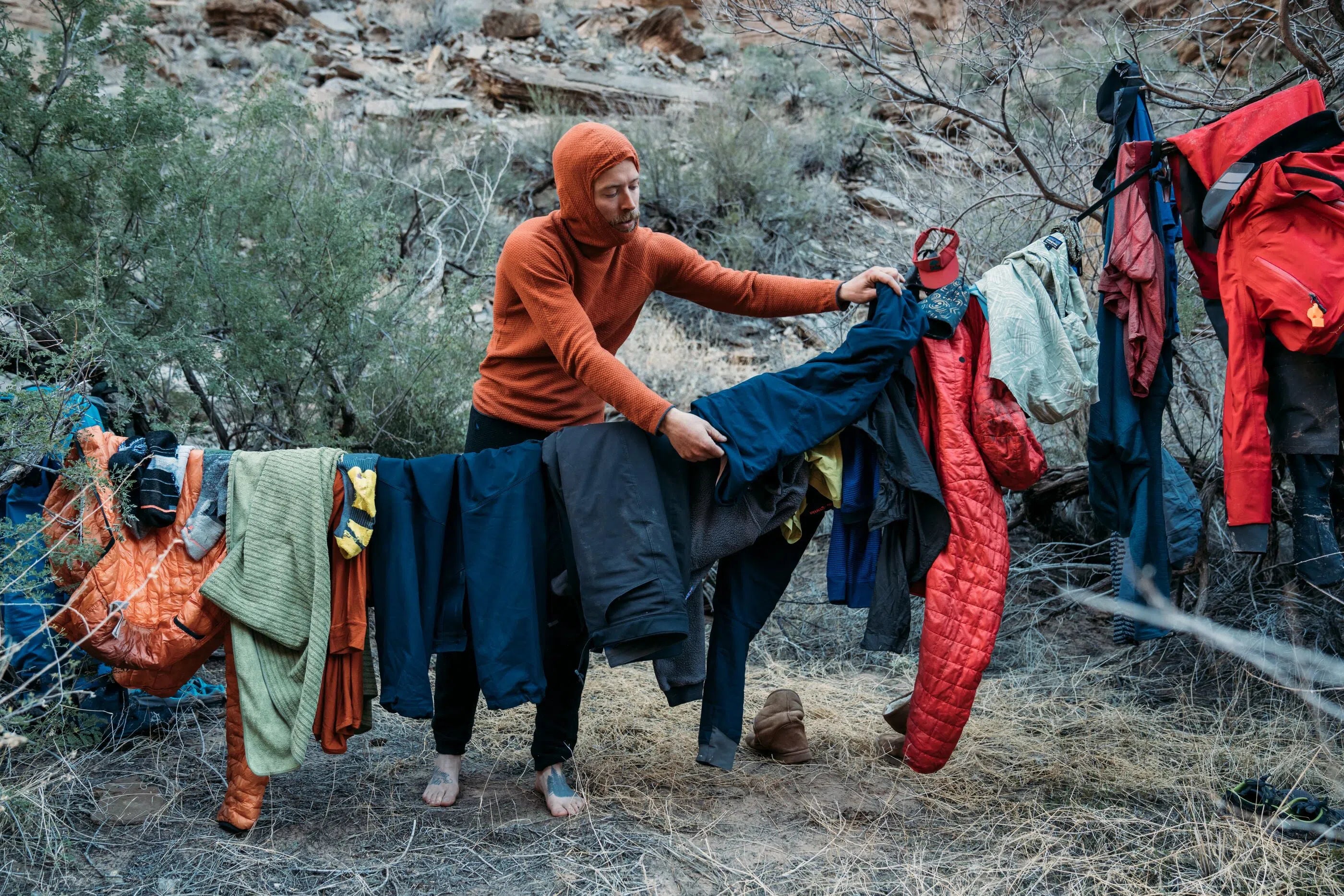 man hanging jackets on clothes line outside